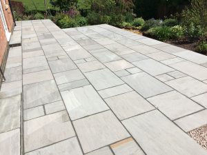 The installation of the Indian sandstone patio in Broughton.