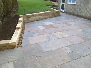 The Indian Sandstone Patio and Timber Sleeper Retaining Wall in Market Harborough Northamptonshire.