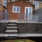 The raised patio with retaining wall and steps